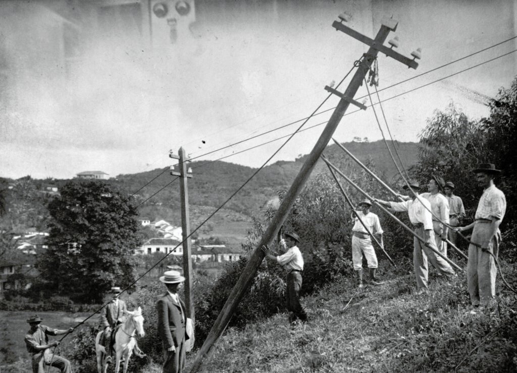 Trabalhores erguem o poste de energia